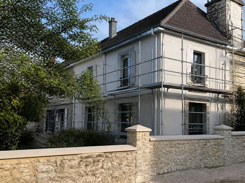 Maison francilienne en rénovation avec toiture, façade et mur de clôture repris